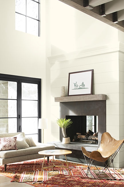 Sala de estar con chimenea, techo alto y paredes blancas pintadas en Blanco Nube OC-130.