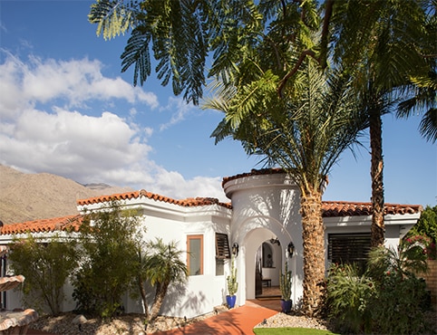 Southwest home with white exterior and clay roofing.