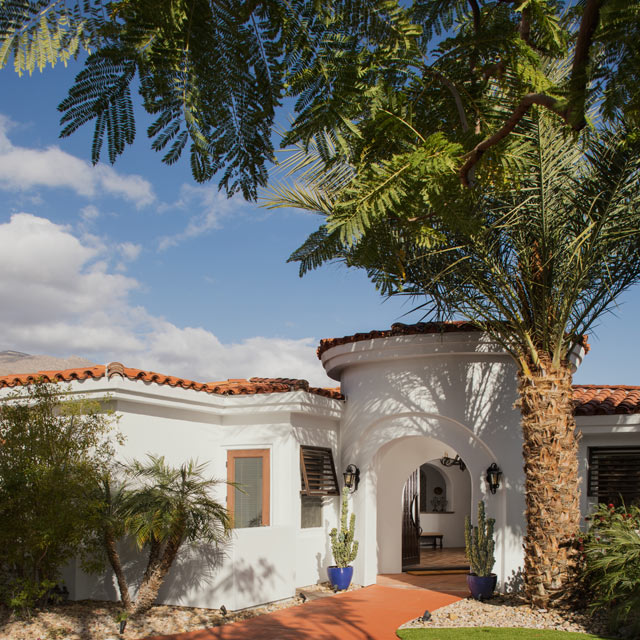 Southwest home with white exterior and clay roofing.