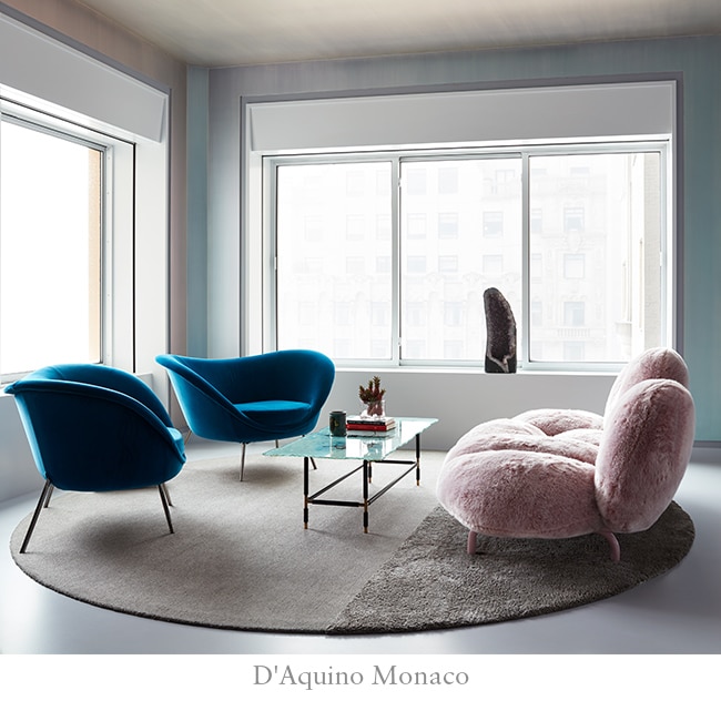 Vibrant living room with light pink couch, two teal chairs and a circle rug.