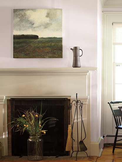 Light mauve walls with a scenic photo hung above a tan fireplace mantel.