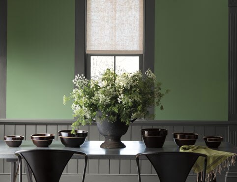 Green painted walls lighten this dining room with dark gray trim, wainscotting and table. Green painted walls lighten this dining room with dark gray trim, wainscotting and table.
