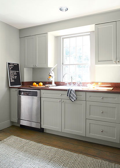 An airy kitchen with walls, cabinets and trim painted in Titanium OC-49, a light greige.