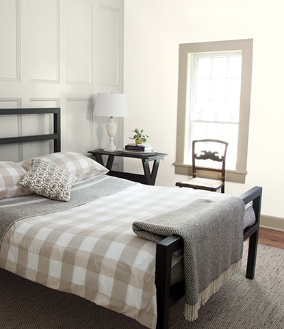 A white bedroom with panelled walls painted in Classic Gray OC-23.