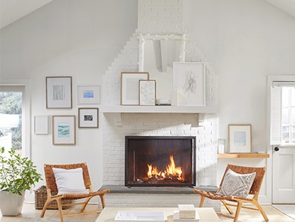 A white living room with a gallery wall, fireplace and walls painted in Winter Snow OC-63.