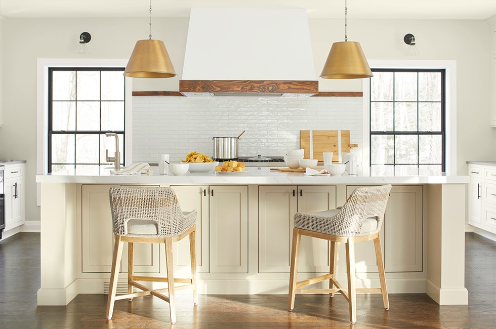 A white kitchen with island painted in Gentle Cream OC-96 and walls painted in Timid White OC-39.