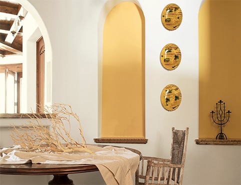 Élégante salle à manger aux murs d’accent jaunes.