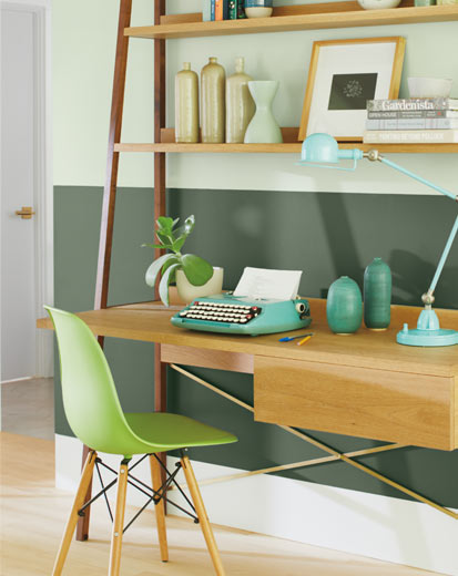 Ce bureau à domicile met en vedette un mur en deux tons de vert et une chaise verte