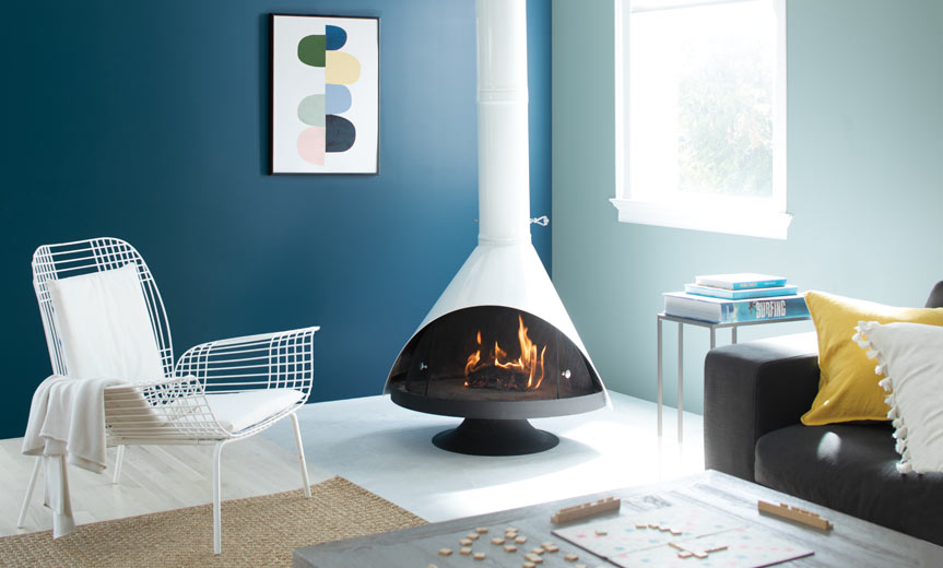 Una sala de estar acogedora se completa con una chimenea retro acompañada por paredes pintadas de azul Una sala de estar acogedora se completa con una chimenea retro acompañada por paredes pintadas de azul