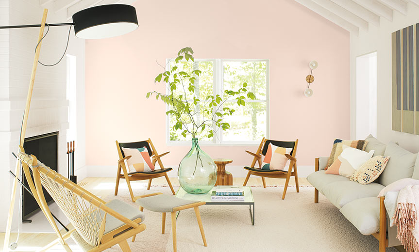 Una sala de estar casual con una pared de acento pintada de rosa claro Una sala de estar casual con una pared de acento pintada de rosa claro