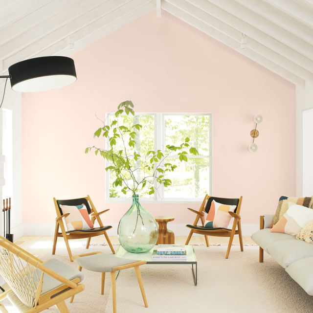 Una sala de estar casual con una pared de acento pintada de rosa claro Una sala de estar casual con una pared de acento pintada de rosa claro