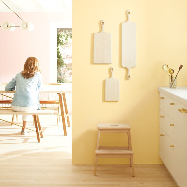 A light kitchen with pale yellow walls and white-painted cabinets