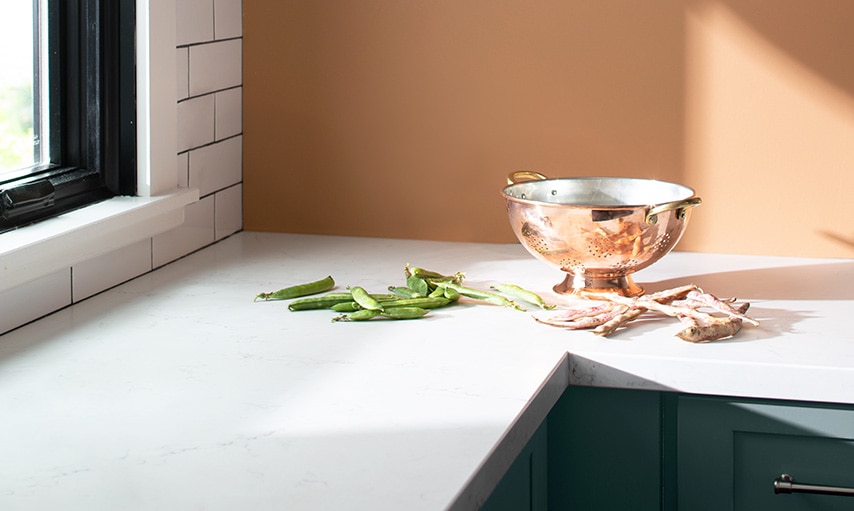 Kitchen corner with white countertops and wall painted in Potters Clay CC-360.