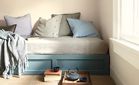 A daybed painted in Aegean Teal 2136-40 and walls in Muslin OC-12.
