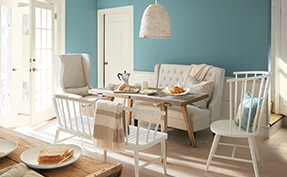 A well-lit dining room area with walls painted in Aegean Teal 2136-40.