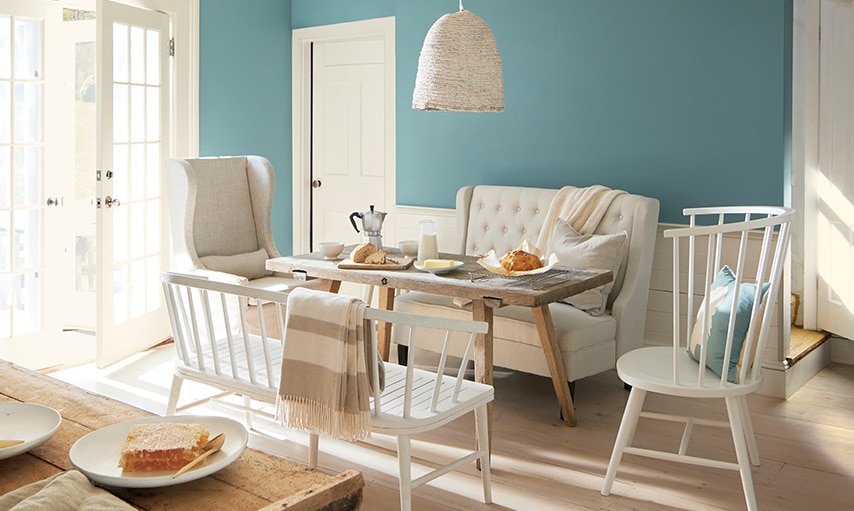 A well-lit dining room area with walls painted in Aegean Teal 2136-40.