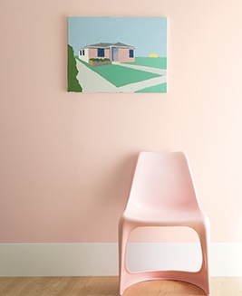 A wall painted with First Light 2102-70 framed by a pink chair.