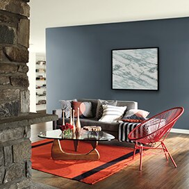 Salon intime dont le mur d’accent gris, le manteau de cheminée en pierre, le plancher de bois et le petit tapis rouge lui donnent son style contemporain et convivial. Salon intime dont le mur d’accent gris, le manteau de cheminée en pierre, le plancher de bois et le petit tapis rouge lui donnent son style contemporain et convivial.