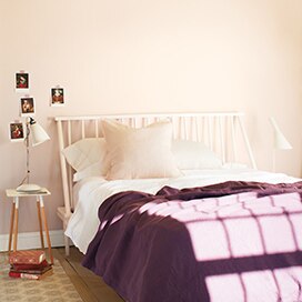 A bedroom with a twin bed, purple blanket, and a wall painted in Foggy Morning 2106-70. A bedroom with a twin bed, purple blanket, and a wall painted in Foggy Morning 2106-70.
