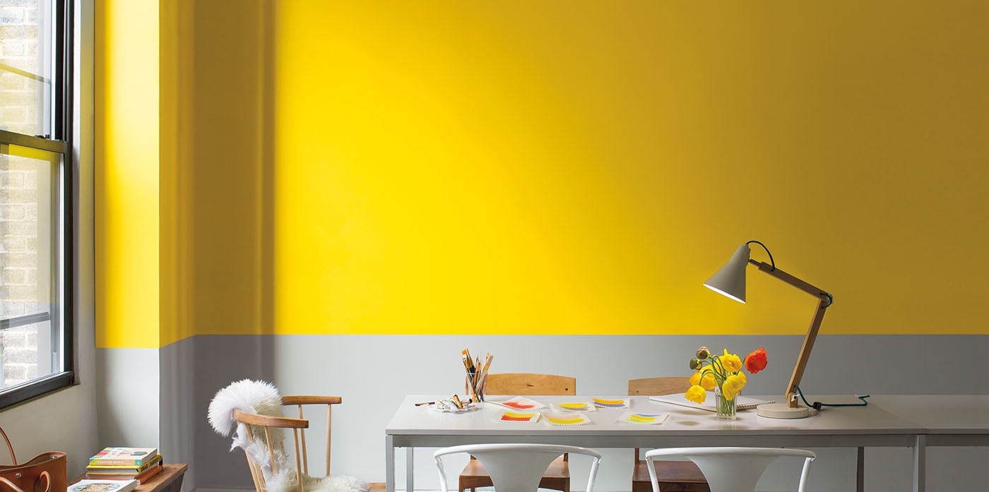 Bright yellow and gray dining room with wood and metal furniture