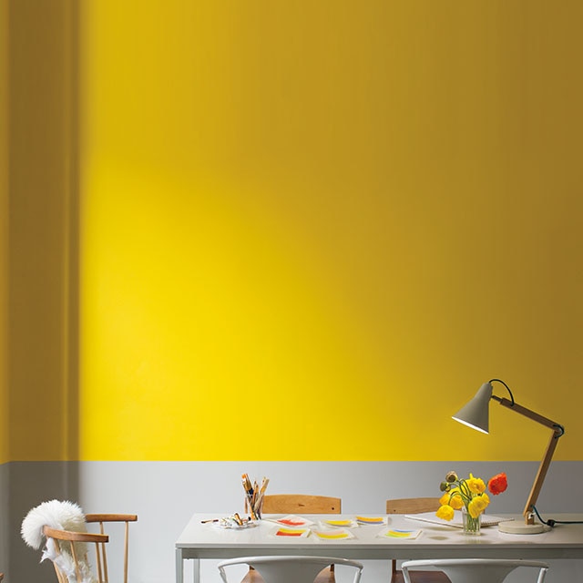 Bright yellow and gray dining room with wood and metal furniture
