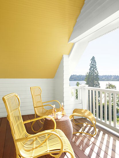 Outside seating area with yellow slanted ceiling and two matching yellow chairs.