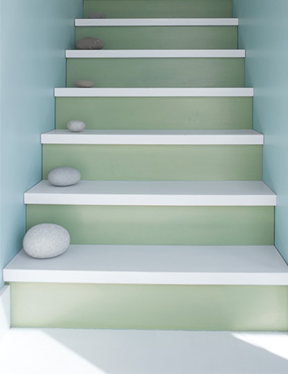 Shades of blue, green and grey lead the way up a staircase accented by a series of round rocks on each step. Shades of blue, green and grey lead the way up a staircase accented by a series of round rocks on each step.