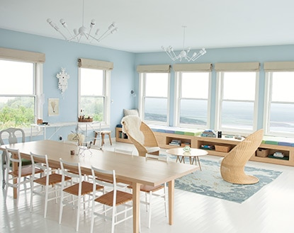 A blond wood dining table underneath two modern chandeliers besides an airy seating area features a wall of windows boasting sweeping Nova Scotia views. A blond wood dining table underneath two modern chandeliers besides an airy seating area features a wall of windows boasting sweeping Nova Scotia views.