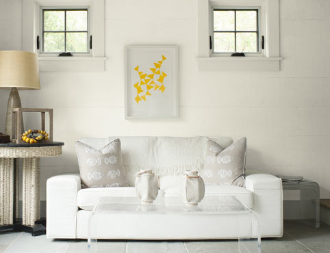 Voici un boudoir lumineux dont les murs blancs en planches à feuillure sont accentués par des meubles et accessoires en tissu neutre.