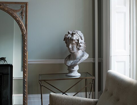 Grey room with tall window, floor mirror and bust Grey room with tall window, floor mirror and bust
