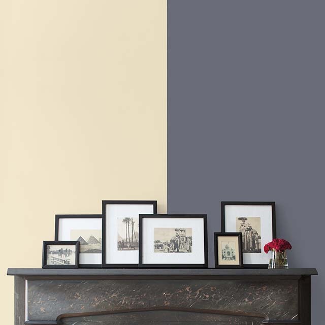 Two-tone wall painted in Subtle AF-310 and Sea Life 2118-40 framed by a black fireplace.