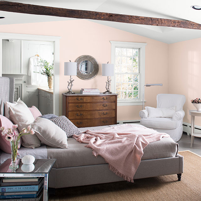A bedroom with walls painted in Mellow Pink 2094-70, displaying the impact of warm paint colors