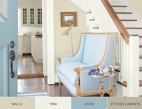 A light blue sofa in an entryway next to a staircase. A light blue sofa in an entryway next to a staircase.
