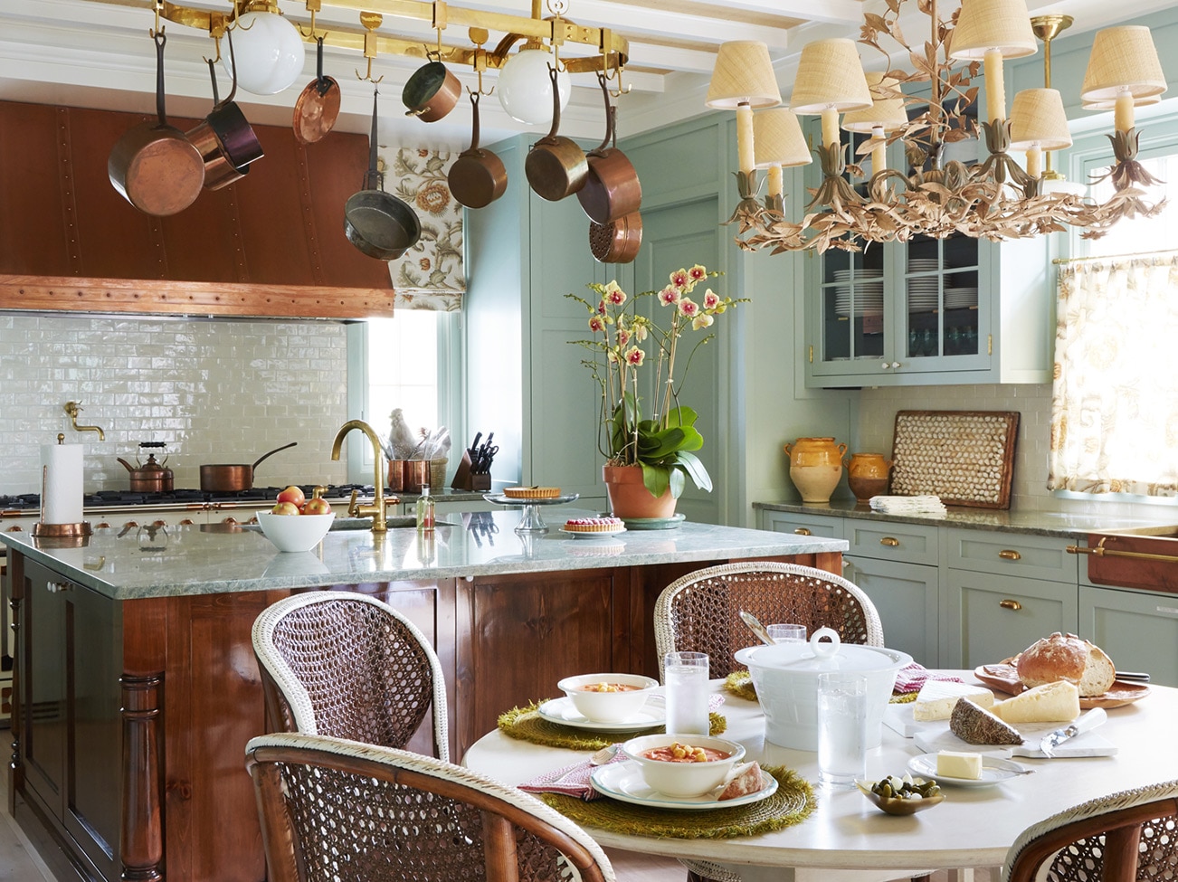 Beamed ceiling kitchen with copper range hood, large wood base island, and elegant small table with French bistro chairs. Beamed ceiling kitchen with copper range hood, large wood base island, and elegant small table with French bistro chairs.