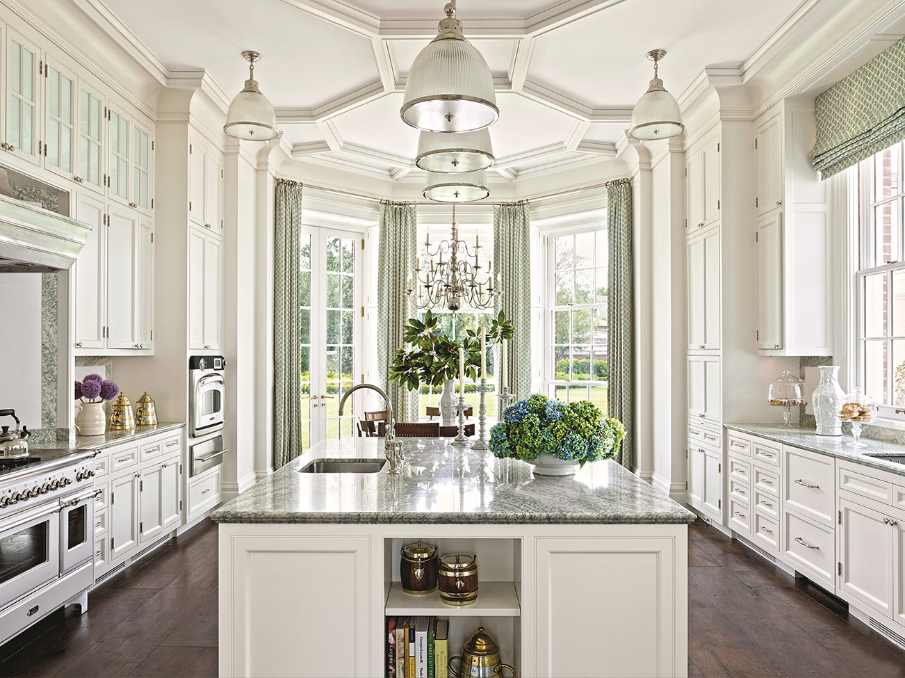 Bright, elegant white kitchen, white cabinetry, marble-topped kitchen island, and floor-to-ceiling windows and French doors.