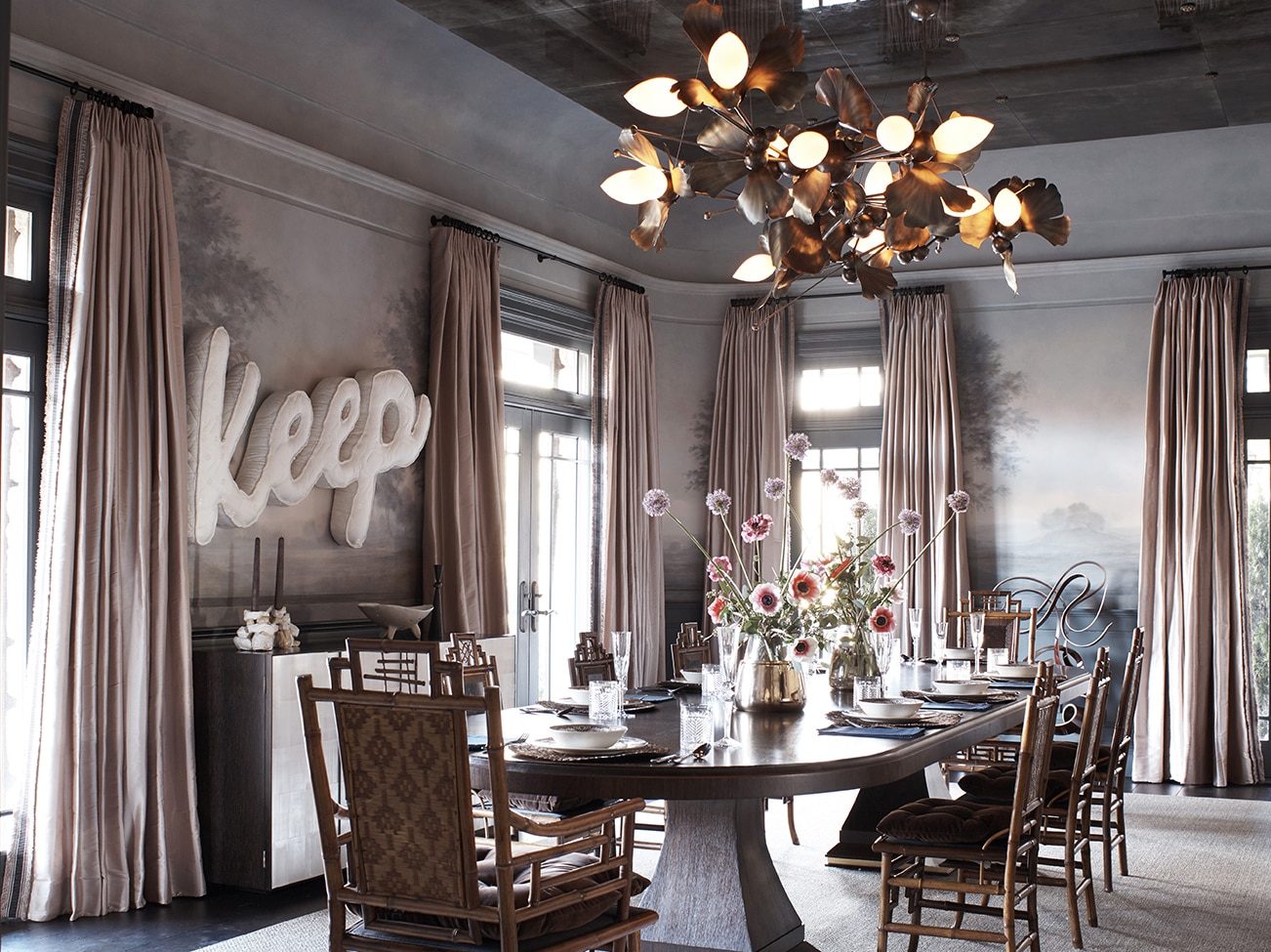 Dining room with large windows, pale curtains, mural walls, mirrored ceiling, floral lighting, table & wooden dining chairs. Dining room with large windows, pale curtains, mural walls, mirrored ceiling, floral lighting, table & wooden dining chairs.