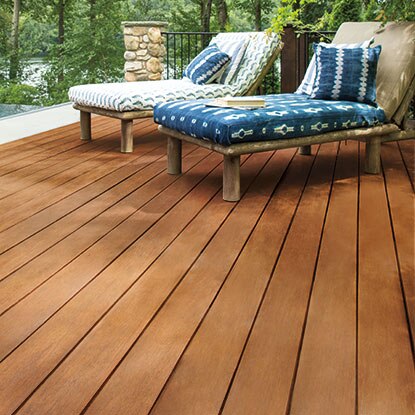 A wooden pool deck with accompanying lounge chairs 