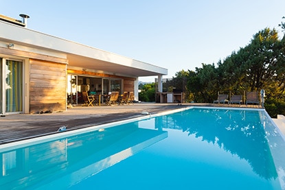 Una piscina al aire libre con plataforma de madera alrededor