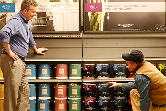 A contractor interacts with staff in a Benjamin Moore store