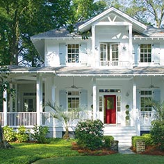 Traditional home with red door and wrap-around porch