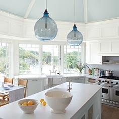Bright, airy light blue kitchen with center island and cliffside view