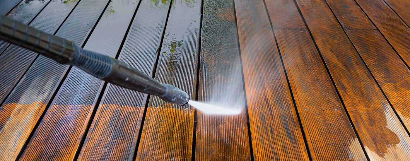 Pressure washing a wood deck prior to painting or staining. 