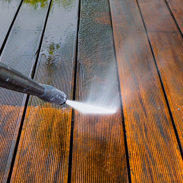 Pressure washing a wood deck prior to painting or staining. 