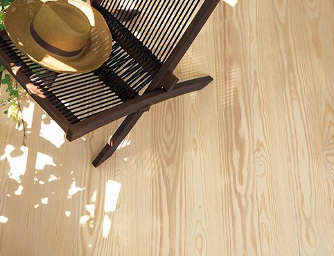 Straw hat perched on a beach chair atop a pine deck. Straw hat perched on a beach chair atop a pine deck.