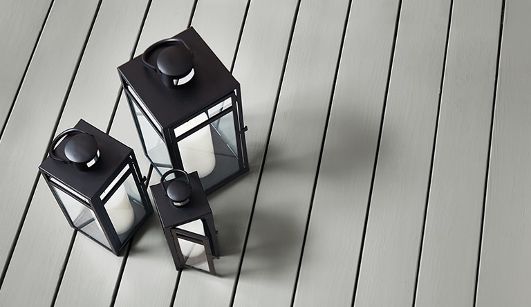 Trois lanternes noires sur une terrasse Gris Platine HC-179 enduite de teinture d’extérieur au fini opaque extra-mat Woodluxe.