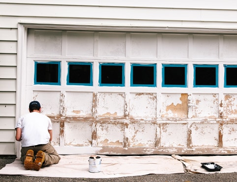 Una persona se prepara para pintar la puerta de un garaje en unos simples pasos, desde la preparación hasta la imprimación y la pintura.