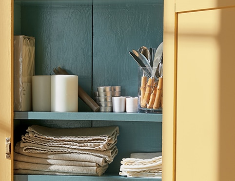 An open cabinet painted in Chestertown Buff HC-9 and Aegean Teal 2136-40.