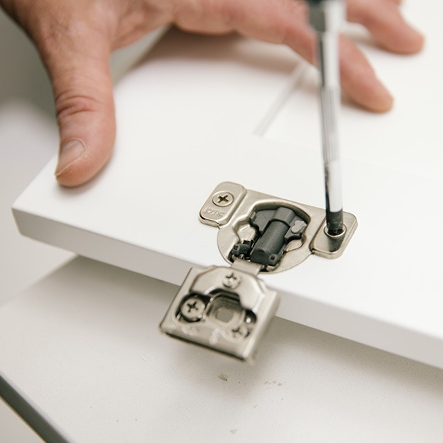 Removing hardware from cabinet frame by using a screwdriver.