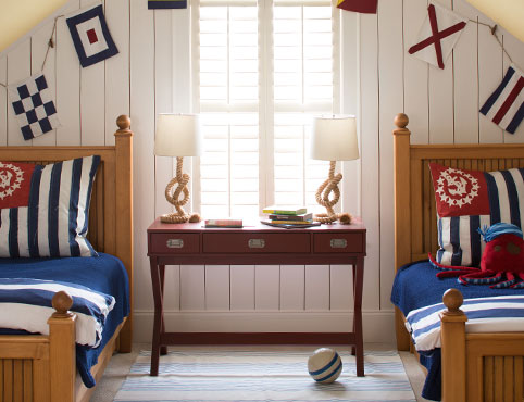 Une chambre à coucher de style marin avec des murs blancs en bois avec feuillures et deux lits jumeaux.