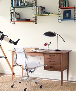 Home office with a wood desk and off white walls.